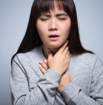 Ból gardła przy przełykaniu – czy może być objawem alergii? Kobieta z chorym gardłem