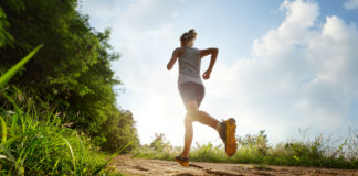 Akcesoria dla biegaczy – opaski odblaskowe Kobieta z opaską odblaskową biegnie