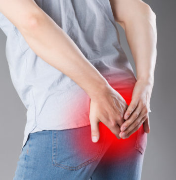 Wstydliwe choroby odbytu Mężczyzna trzyma się za tyłek