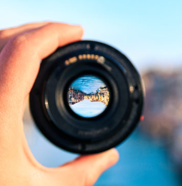 Wybór obiektywu fotograficznego. Na co zwrócić uwagę? Obiektyw aparatu w dłoni