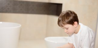 O tym musisz wiedzieć, jeżeli Twoje dziecko ma biegunkę Chłopiec siedzący na toalecie z papierem toaletowym w rękach