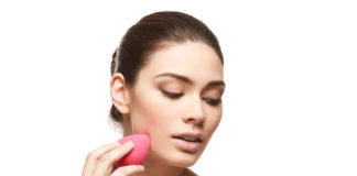 Jak prawidłowo używać gąbeczki do makijażu? Kobieta używająca różowej gąbeczki do makijażu