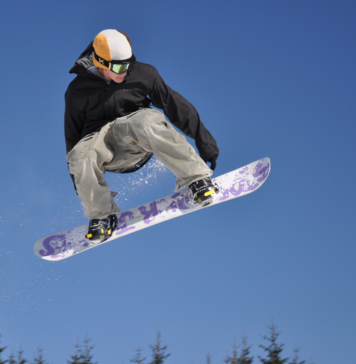 Pomysł na ekstremalny prezent dla faceta Mężczyzna skaczący na snowboardzie