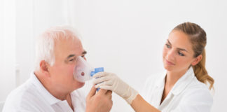 Mukowiscydoza a kaszel mężczyzna oddychający dzięki inhalatorowi