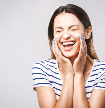 Jak pielęgnować skórę wokół oczu? uśmiechnięta kobieta z kremem pod oczami