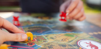 Jak nie nudzić się w podróży? Zagrajmy w planszówki! dwie osoby grające w planszówkę w podróży