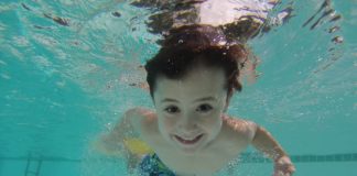 Jak czyścić baseny stelażowe? Dziecko pływające w basenie