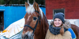 Zimowy ubiór do stajni – co założyć, aby nie zmarznąć? uśmiechnięta dziewczyna z koniem zimą