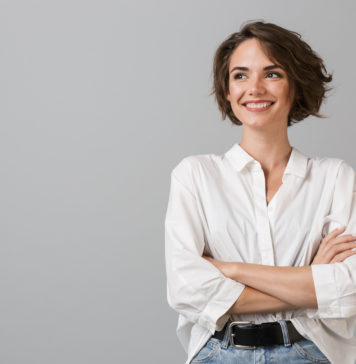 Trendy modowe na wiosnę 2020. Co powinno zagościć w Twojej szafie? kobieta w białej koszuli i jeansach