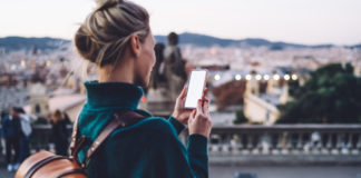 Na wycieczkę ze smartfonem: które aplikacje na telefon pomagają w podróżowaniu? dziewczyna z plecakiem w podróży ze smartfonem