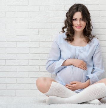 Zielona dieta przyszłej mamy? Czemu nie! młoda kobieta w ciąży w błekitnej sukience i podkolanówkach