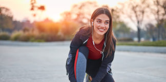 Koszulki biegowe – inwestycja dla Twojego komfortu kobieta w stroju do biegania zawiązuje but