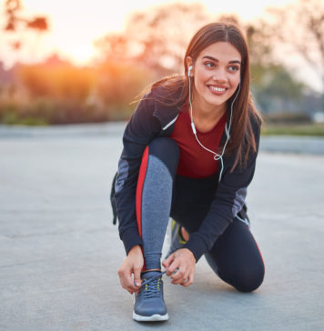 Koszulki biegowe – inwestycja dla Twojego komfortu kobieta w stroju do biegania zawiązuje but