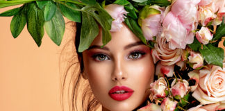 Mniej lub bardziej oficjalnie – propozycje makijażowe na różne okazje kobieta w pięknym makijażu z kwiatami przy twarzy