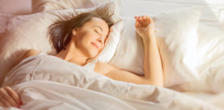 Najlepsze pozycje do snu, dzięki którym będzie Ci się lepiej spało kobieta śpiąca na plecach w łóżku