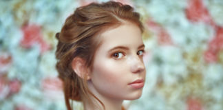 Jak rozpoznać swój typ skóry i zacząć stosować odpowiednie kosmetyki? rudowłosa dziewczyna o alabastrowej skórze na kwiatowym tle