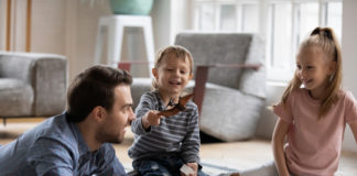 Jakie zabawki rozwijają wyobraźnię i kreatywność dziecka? Postawmy na klasykę wesołe dzieci z ojcem budujące konstrukcje z klocków drewnianych