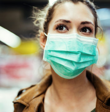 Szybko i mądrze, czyli o robieniu zakupów w czasie epidemii dziewczyna w maseczce na twarzy na tle supermarketu