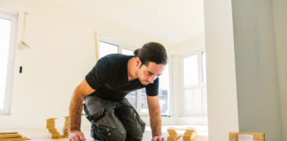 Czym kierować się w wyborze ekipy remontowej? mężczyzna układający panele