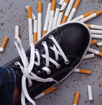 Rzucenie palenia – jak to zrobić? but depczący rozsypane papierosy