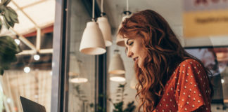 Myślisz o prowadzeniu własnego bloga? Te wskazówki pomogą Ci w tym rudowłosa dziewczyna przy laptopie pisząca na blogu