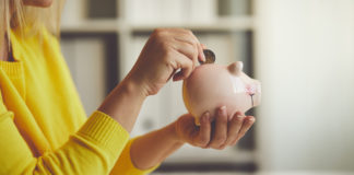 8 porad jak zacząć oszczędzać na produktach kobieta wkładająca monetę do świnki skarbonki