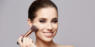 Podkład kryjący bez efektu maski? Pomagamy wybrać! kobieta z pędzlem do makijażu