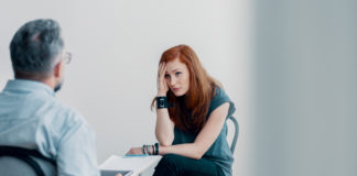 Kiedy warto skorzystać z wizyty u psychoterapeuty? młoda kobieta na sesji psychoterapeutycznej