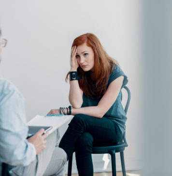 Kiedy warto skorzystać z wizyty u psychoterapeuty? młoda kobieta na sesji psychoterapeutycznej