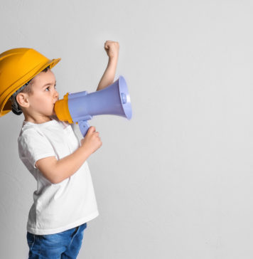 Jak nauczyć dziecko samodzielności, czyli kilka słów o zabawkach Klein chłopiec w kasku z zabawkowym megafonem