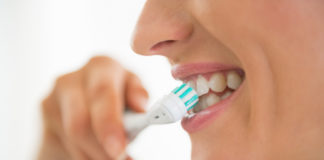 Jak prawidłowo myć zęby? zbliżenie na kobietę myjącą zęby