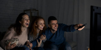Nie tylko Harry Potter. Recenzujemy mniej znane filmy dla nastolatków i młodych dorosłych! rozbawieni młodzi ludzie przed telewizorem