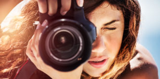Początki przygody z aparatem cyfrowym – jakimi obiektywami oraz akcesoriami warto się zainteresować? piękna kobieta z rozpuszczonymi włosami robiąca zdjęcia