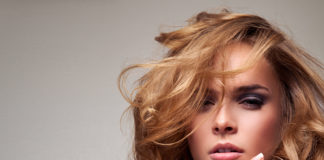 Tych zabiegów medycyny estetycznej nie zrobisz latem delikatna blondynka z długimi włosami z dłonią przy twarzy