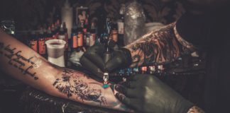 Tatuaże wchodzą do mainstreamu tatuażysta wykonujący tatuaż na kobiecej ręce