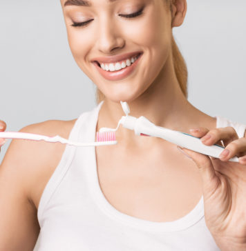 Wybielające pasty do zębów – ścierne, enzymatyczne, a może z nadtlenkiem? kobieta nakładająca pastę do zębów na szczoteczkę