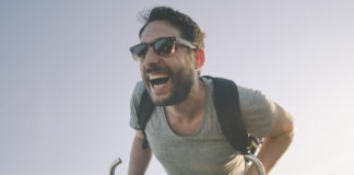 Popularne akcesoria i ciekawe rozwiązania dla rowerów – sprawdź, które mogą Ci się przydać i jak da się je zamontować roześmiany mężczyzna na rowerze