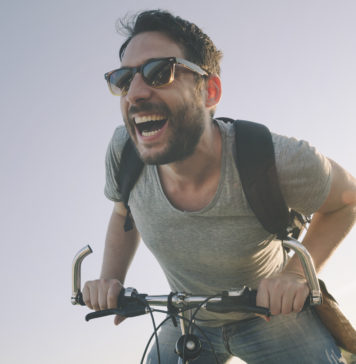 Popularne akcesoria i ciekawe rozwiązania dla rowerów – sprawdź, które mogą Ci się przydać i jak da się je zamontować roześmiany mężczyzna na rowerze