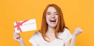 Czy karta podarunkowa to odpowiedni prezent? ruda kobieta z kartą podarunkową