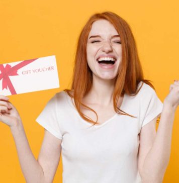 Czy karta podarunkowa to odpowiedni prezent? ruda kobieta z kartą podarunkową