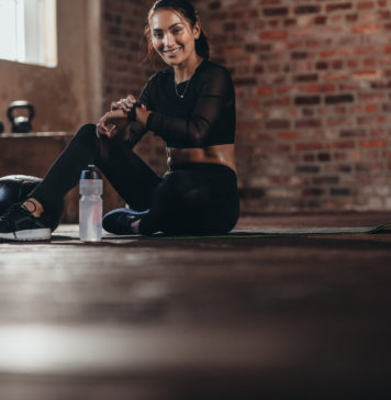 Kiedy i dlaczego warto zdecydować się na zakup smartwatcha? kobieta na siłowni z zegarkiem