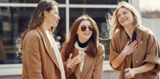 Różne kroje płaszczy damskich – jak je rozróżnić i wybrać idealny model dla siebie? trzy kobiety w beżowych płaszczach