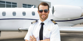 Jaką drogę musi pokonać przyszły, zawodowy pilot samolotu? przystojny pilot na tle samolotu