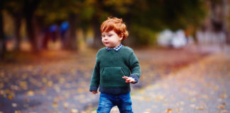 Pierwsze buty dla malucha rudy chłopiec w zimowych butach