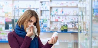 Zatkany nos – przyczyny. Jak leczyć? kobieta z zatkanym nosem w aptece