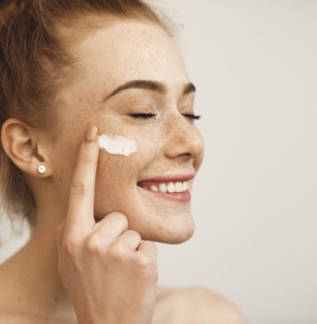 Czego nie może zabraknąć w damskiej kosmetyczce? kobieta z kremem na twarzy