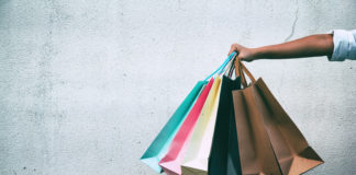 Zakupoholizm – skąd się bierze, jakie ma objawy i co zrobić, aby mu przeciwdziałać? zbliżenie na rękę trzymającą torby na zakupy