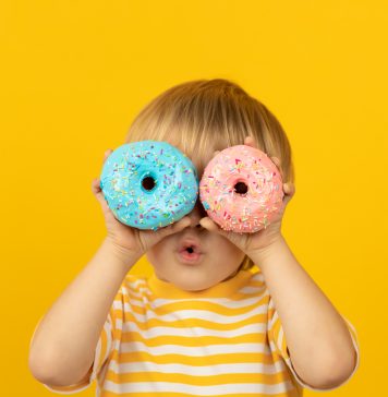 Kiedy warto udać się z dzieckiem do psychodietetyka dziecięcego? małę dziecko z pączkami na twarzy