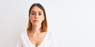 Intensywniejsze owłosienie na twarzy u kobiet – skąd się bierze ten problem i jak się z nim uporać? smutna kobieta patrząca w obiektyw
