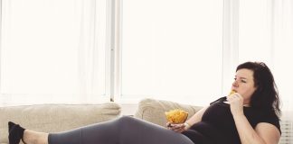 Zagrożenia wynikające z braku aktywności fizycznej kobieta z chipsami przed tv